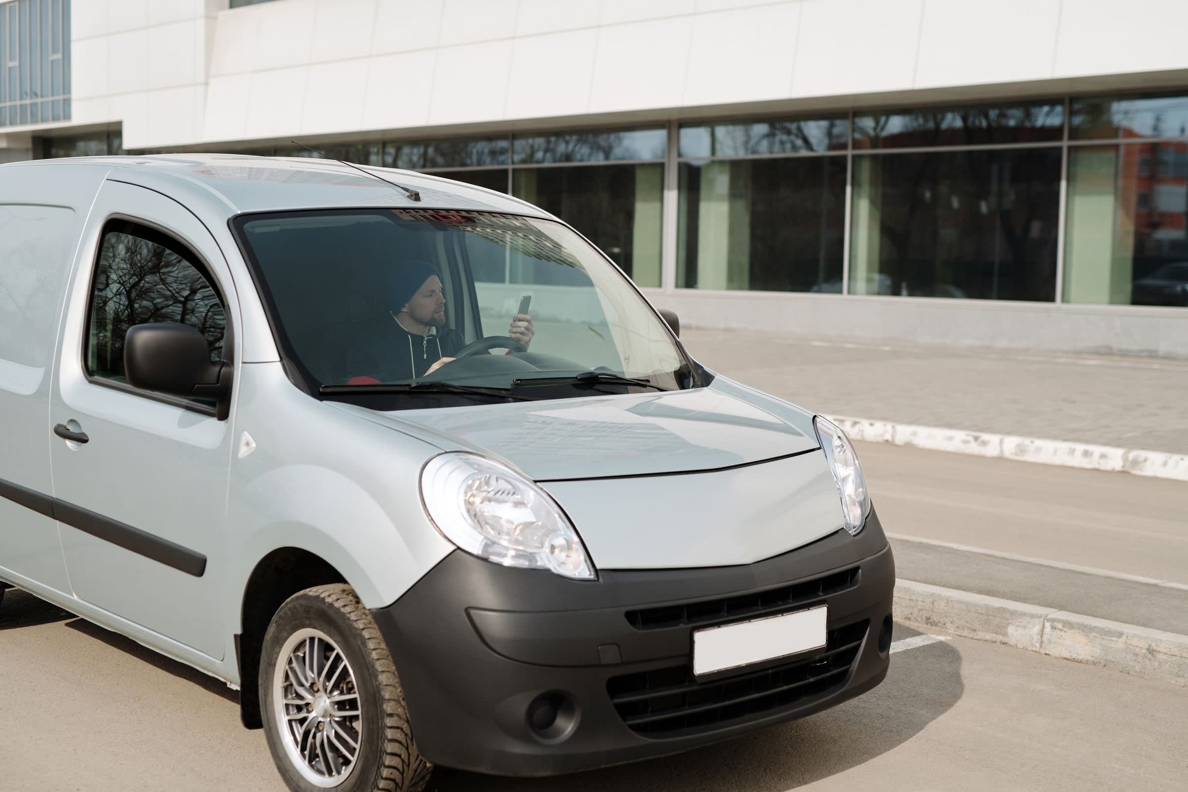 配送に向かう軽貨物車とドライバー
